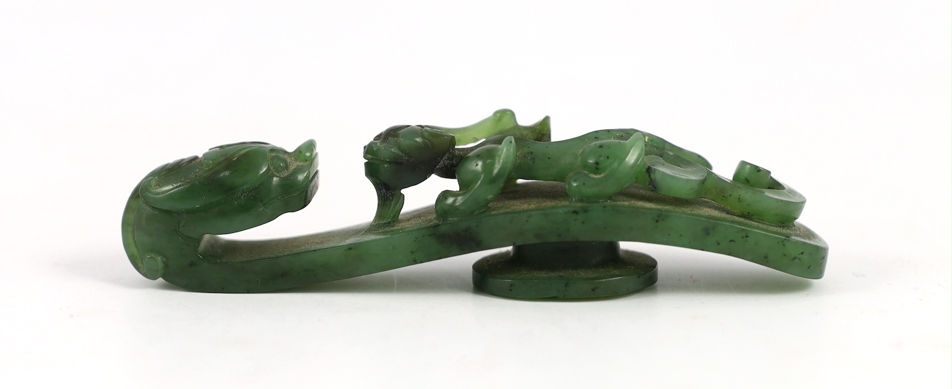A Chinese bright spinach green jade ‘dragon’ belt hook, 18th/19th century, 9.5cm long
